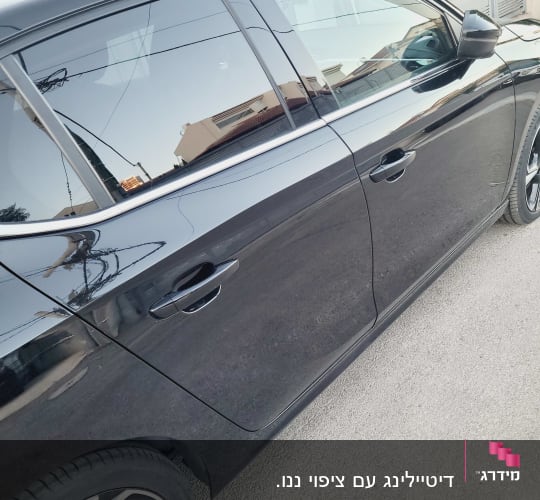 רכב שחור לאחר ניקוי והברקה, חונה ברחוב